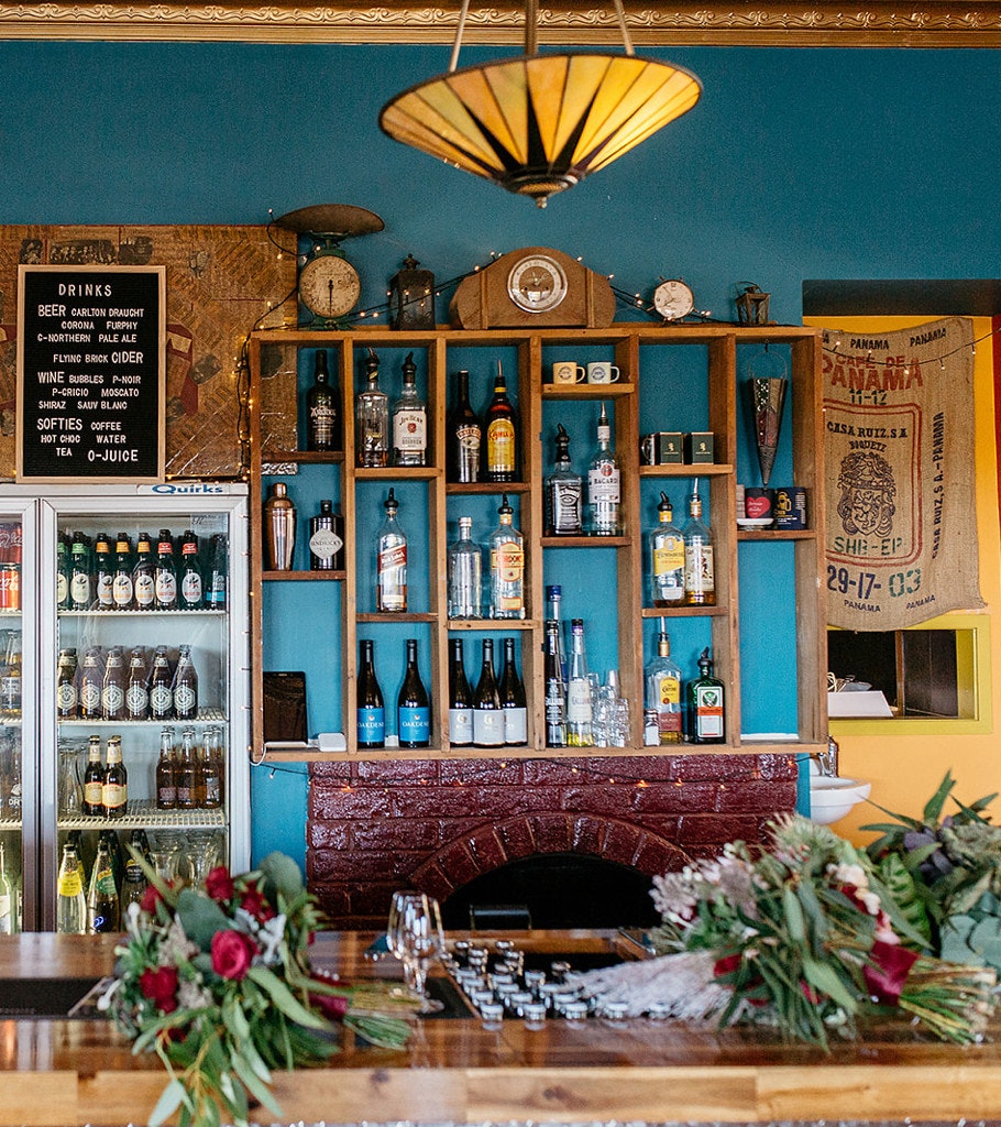 Behind bar with wedding floral arrangements.